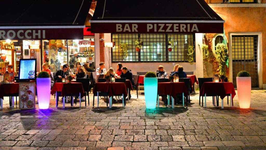 Pessoas no restaurante e pizzaria, ao ar livre, em Veneza, Itália 