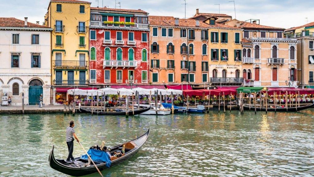 Gondoleiro remando na gôndola no grande canal em Veneza, Itália.