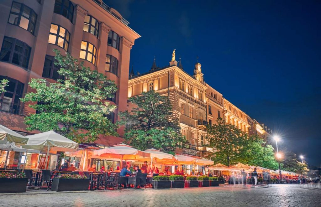 Cafés e restaurantes na praça principal à noite em Cracóvia, Polônia